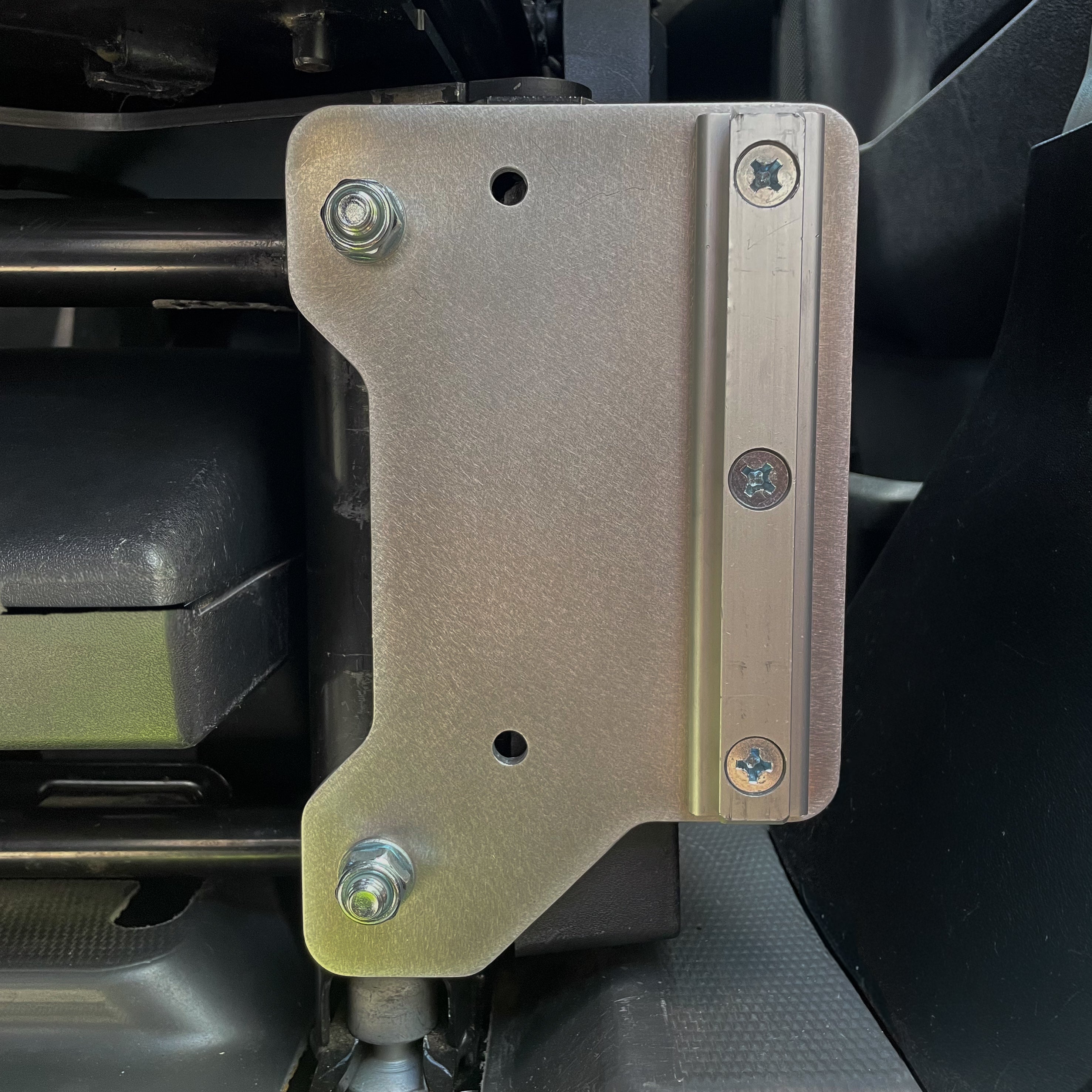 Ram ProMaster Lagun table mount bracket installed on factory seat base, reversible aluminum bracket showing alternate face mounting position without table arm