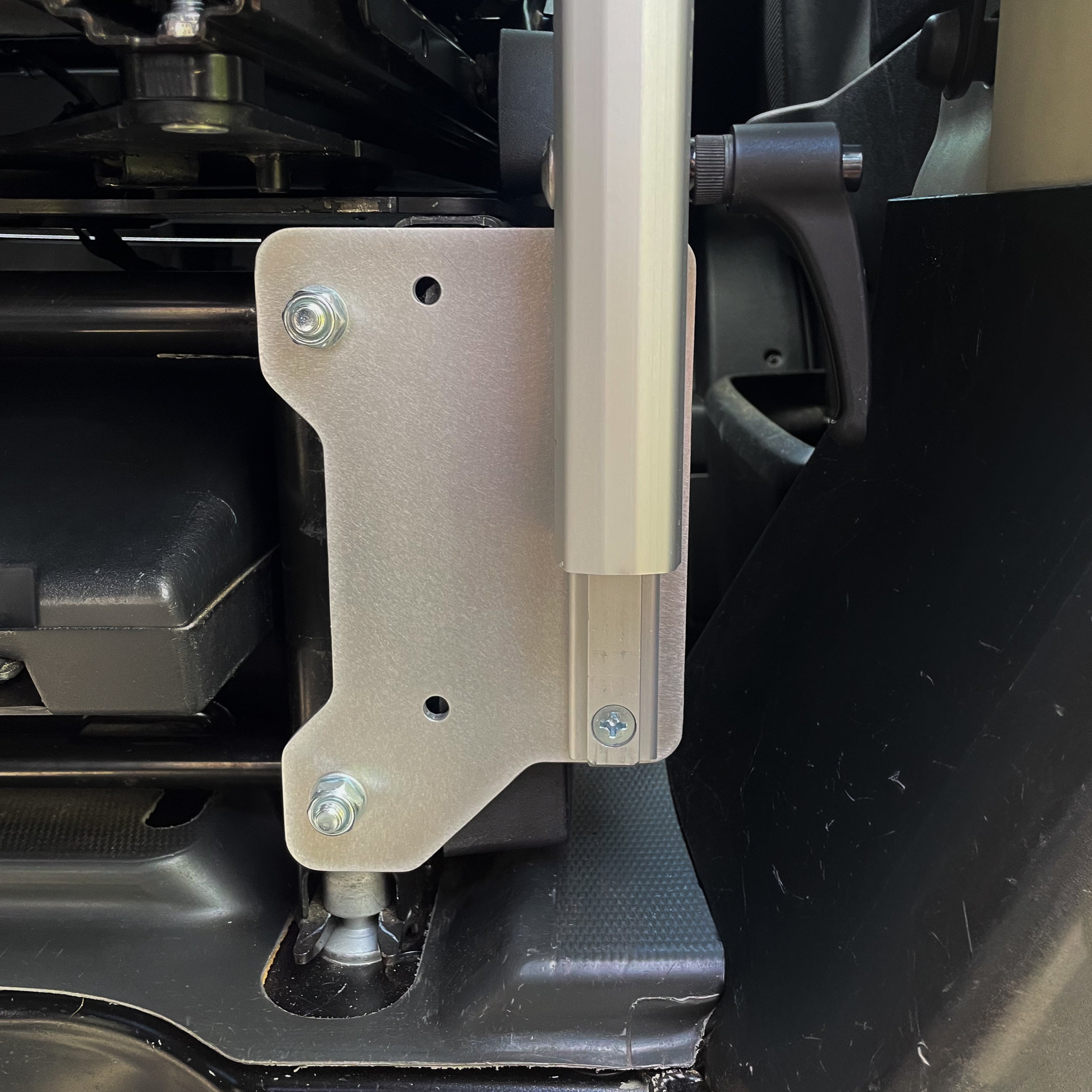Stoutlander ProMaster Lagun mount bracket installed on factory seat base with Lagun table arm, outboard position, CNC machined aluminum